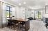 Bright and airy common room with large windows, modern seating area, sleek workspace, and stylish furnishings.
