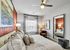 Elegant bedroom featuring plush bedding, modern decor, and abundant natural light from a large window, with stylish lamps and artwork enhancing the tranquil atmosphere.
