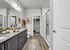 Elegant bathroom featuring granite countertops, modern fixtures, and a spacious walk-in closet with ample storage.