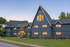 Charming modern apartment building with stylish architecture, nestled in a serene green setting at dusk.