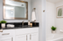 Elegant bathroom featuring a sleek black granite countertop, modern fixtures, and a soothing ambiance. Includes a chic white vanity, decorative greenery, and a luxurious bathtub for ultimate relaxation.