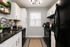 Modern kitchen featuring sleek black appliances, elegant white cabinets, and stylish mosaic backsplash, exuding contemporary charm and functionality.