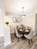 Elegant dining area with a sophisticated table set for six, surrounded by plush chairs and accented with modern wall art.