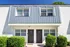 Charming townhouse exterior with sleek metal roofing, classic brick facade, and inviting front entry.