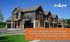 Elegant townhouse complex with peaked roofs, stone siding, and balconies, set in a lush, green environment.
