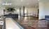 Inviting clubhouse interior featuring a sleek modern design with stone fireplace, spacious seating area, and shuffleboard table for entertaining.