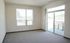 Bright and airy living space with plush carpeting and large windows offering scenic views and ample natural light.