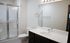 Elegant modern bathroom featuring a sleek glass shower, polished vanity with ample storage, and contemporary fixtures.