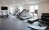 Modern fitness center with state-of-the-art exercise equipment, including treadmills, stair climber, stationary bikes, and a comprehensive free weight set.