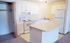 Bright and modern kitchen with white cabinetry, spacious countertops, and a cozy breakfast island.