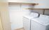 Spacious laundry room featuring modern washer and dryer with ample shelving for storage.