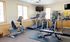 Inviting fitness center with modern cardio equipment, ample natural light, and fresh exercise atmosphere.