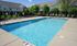 Inviting outdoor swimming pool surrounded by comfortable lounge chairs and lush greenery, perfect for relaxation and leisure.