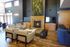 Elegant living room with a cozy fireplace, modern seating area, and vibrant plant wall, perfect for relaxation.
