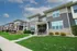 Charming townhouse with modern facade, lush green lawn, and welcoming front porch, perfect for family living.