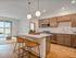 Modern kitchen with elegant wooden cabinetry, island seating, and seamless open-plan living area with large sliding doors for natural light.