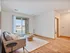 Bright and inviting living room with wood floors, a cozy sofa, and modern glass doors opening to a sunny patio, perfect for relaxation.