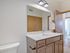 Bright and modern bathroom featuring sleek vanity with ample storage and large mirror, perfect for stylish living.