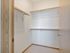 Spacious walk-in closet with wooden shelves and ample hanging space for stylish organization.