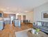 Modern open-plan living space featuring a sleek kitchen with stainless steel appliances, a cozy dining area, and a stylish lounge with elegant decor.