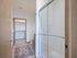 Elegant bathroom featuring a glass shower door, modern fixtures, cozy rug, and a spacious walk-in closet.