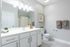 Modern bathroom featuring stylish white cabinets, elegant lighting, and minimalist decor.