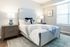 Inviting bedroom featuring a stylish bed with decorative pillows, wooden nightstands, and soft lighting.