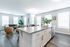 Bright and spacious open-concept kitchen and living area with modern decor and large windows.