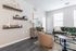 Chic living room with modern decor, featuring a plush armchair, stylish shelving, and a cozy gray sofa.