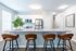Modern kitchen with sleek countertops, stainless steel appliances, and stylish bar stools.