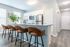 Contemporary kitchen featuring a stylish granite countertop with bar seating, stainless steel appliances, and elegant lighting.