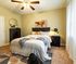 Inviting bedroom with warm lighting, featuring a stylish bed, modern decor, and a plush carpet.