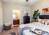 Chic bedroom with modern decor, cozy textiles, and an ensuite bathroom.