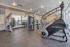 Spacious gym with modern exercise equipment including a StairMaster, weights, and training machines.