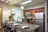 Contemporary kitchen with granite countertops, stainless steel appliances, and elegant lighting.