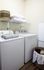 Cozy laundry room with modern washer, dryer, and organized shelving.