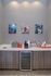 Modern refreshments corner with stylish cabinets, a beverage fridge, and art prints on the wall.