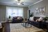 Inviting living room with plush dark sofas, geometric rug, and elegant decor.