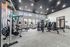 Spacious gym facility with modern exercise equipment, large windows, and stylish lighting.