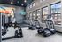 Modern fitness center with treadmills, ellipticals, and vibrant wall art near large windows.