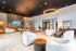 Sophisticated lounge featuring modern seating, pool table, and stylish decor with overhead lighting.