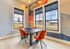Contemporary dining area with artistic decor and vibrant orange chairs.