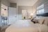 Inviting bedroom with plush bedding, stylish decor, and natural light from a window.