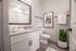 Bright and modern bathroom with granite countertop, framed mirror, and stylish decor.