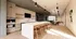Modern kitchen with a large island, elegant stools, and spacious dining area bathed in natural light.