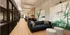 Elegant hallway with modern decor, featuring a stylish sofa, artistic wall paintings, and ambient lighting.