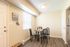 Cozy dining area with a round glass table, four chairs, and stylish decor in a bright room.