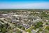 Aerial view of a sprawling residential community with lush greenery, well-maintained streets, and diverse homes.