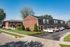 Charming brick apartment complex with manicured landscaping and spacious parking in a quiet neighborhood.