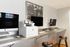 Modern home office with dual monitors, printer, and stylish seating.